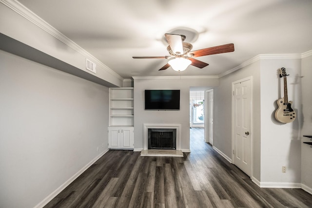 unfurnished living room with dark wood finished floors, a ceiling fan, a fireplace with raised hearth, crown molding, and baseboards