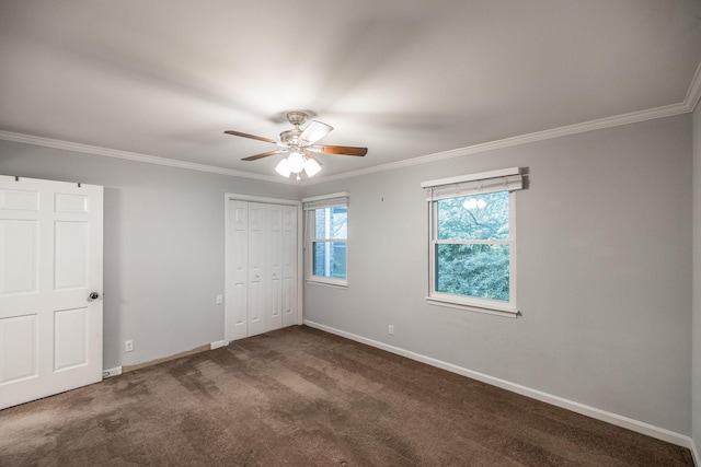 unfurnished bedroom featuring baseboards, ornamental molding, carpet, a ceiling fan, and a closet