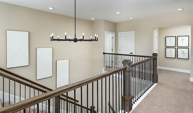 hallway with carpet floors, a notable chandelier, an upstairs landing, and recessed lighting