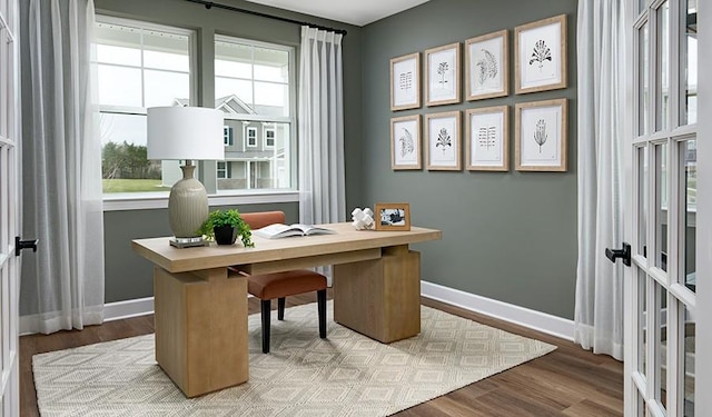 home office featuring french doors, wood finished floors, and baseboards