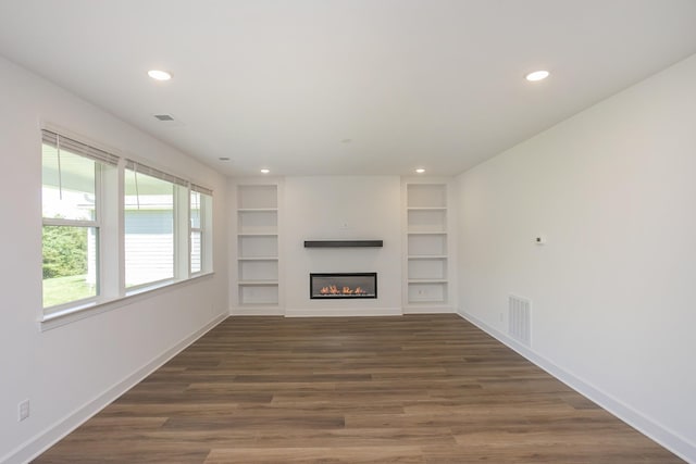 138 W Cassa Way, Mount Juliet, TN 37122 - unfurnished living room with recessed lighting, baseboards, dark wood-style flooring, built in shelves, and a glass covered fireplace