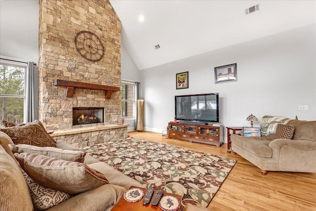 1520 Raulston Falls Rd, Jasper, TN 37347 - living area featuring a stone fireplace, high vaulted ceiling, visible vents, and wood finished floors