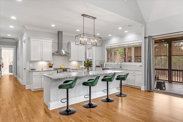 1520 Raulston Falls Rd, Jasper, TN 37347 - kitchen featuring a sink, white cabinets, wall chimney range hood, a kitchen island, and ornamental molding