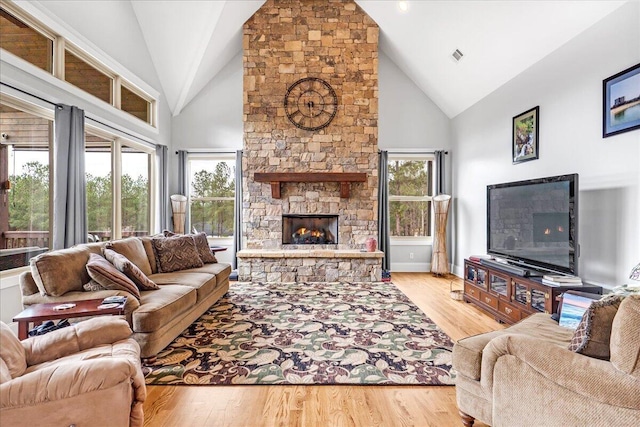 1520 Raulston Falls Rd, Jasper, TN 37347 - living room with light wood-type flooring, visible vents, a stone fireplace, and high vaulted ceiling