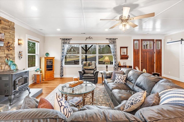 234 Lookout View Dr, Jasper, TN 37347 - living area featuring a wood stove, crown molding, a barn door, and light wood-style floors