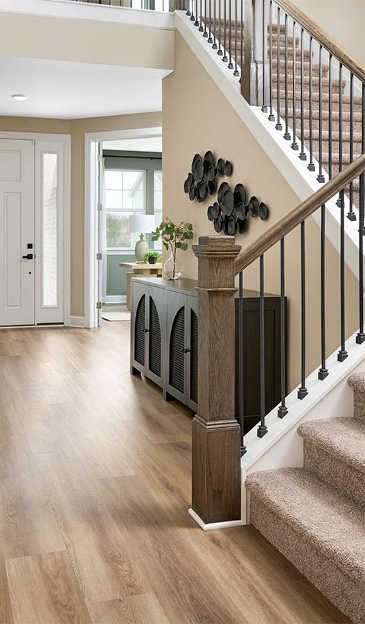 stairs with wood finished floors, baseboards, and a high ceiling