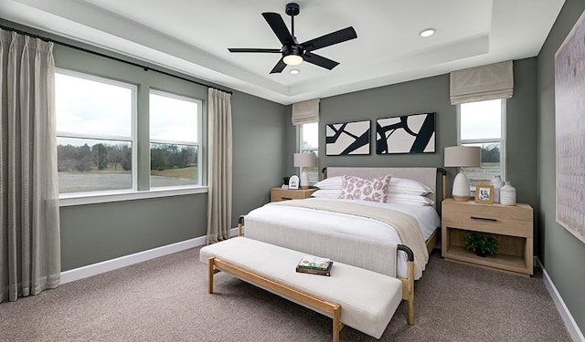 carpeted bedroom with a tray ceiling, baseboards, ceiling fan, and recessed lighting