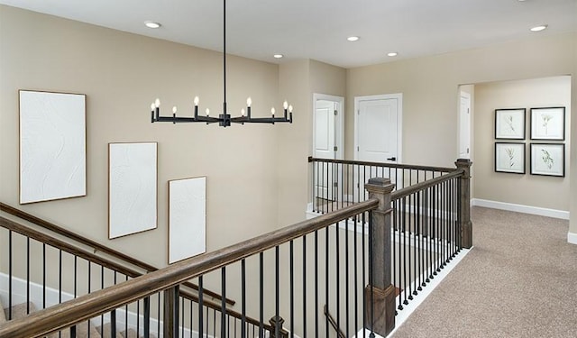 hallway featuring recessed lighting, carpet, an upstairs landing, and a notable chandelier