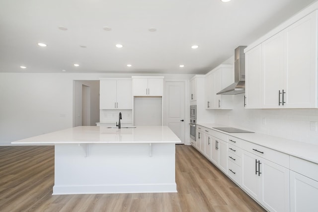 135 W Cassa Way, Mount Juliet, TN 37122 - kitchen with wall chimney exhaust hood, a sink, stainless steel oven, decorative backsplash, and light wood finished floors