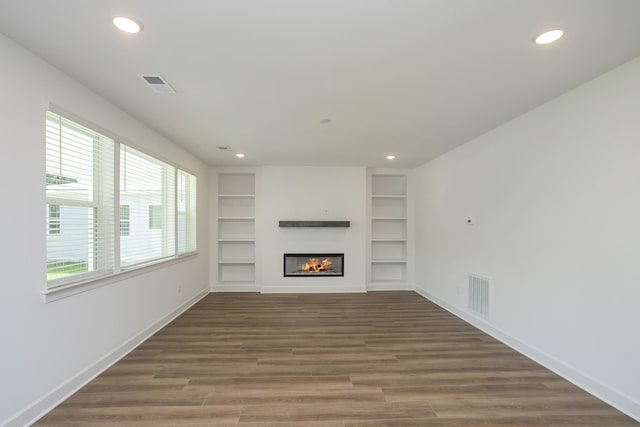 135 W Cassa Way, Mount Juliet, TN 37122 - unfurnished living room featuring recessed lighting, wood finished floors, a glass covered fireplace, built in shelves, and baseboards
