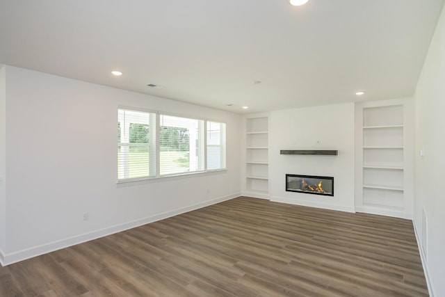 135 W Cassa Way, Mount Juliet, TN 37122 - unfurnished living room with baseboards, built in shelves, wood finished floors, a glass covered fireplace, and recessed lighting