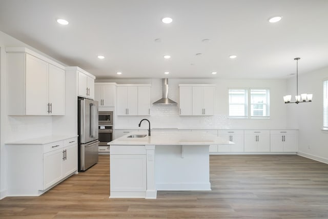 136 W Cassa Way, Mount Juliet, TN 37122 - kitchen with appliances with stainless steel finishes, wall chimney exhaust hood, a sink, light countertops, and tasteful backsplash