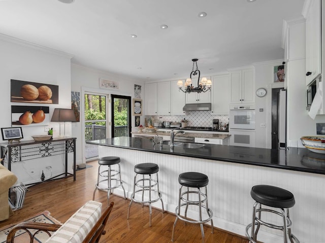 1229 Vintage Pl, Nashville, TN 37215 - kitchen with white double oven, a sink, stainless steel microwave, under cabinet range hood, and white cabinets