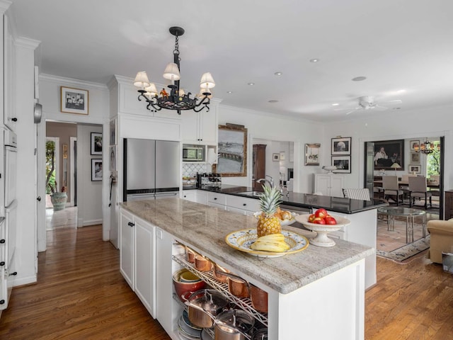 1229 Vintage Pl, Nashville, TN 37215 - kitchen featuring appliances with stainless steel finishes, a chandelier, a peninsula, ornamental molding, and a sink