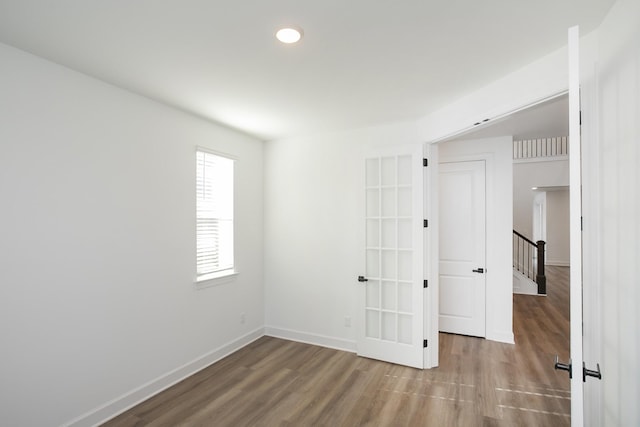 empty room with wood finished floors, baseboards, and recessed lighting