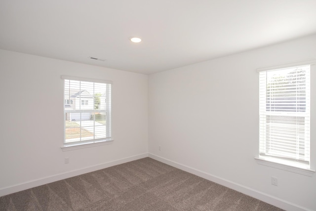 empty room with carpet floors, baseboards, visible vents, and recessed lighting