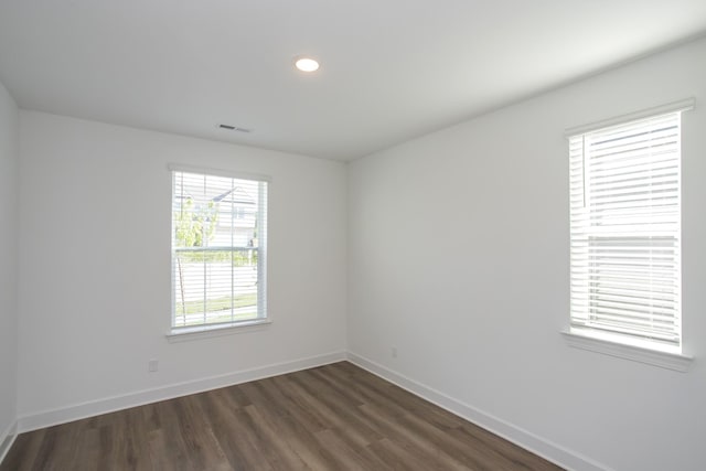spare room featuring baseboards, recessed lighting, dark wood finished floors, and visible vents