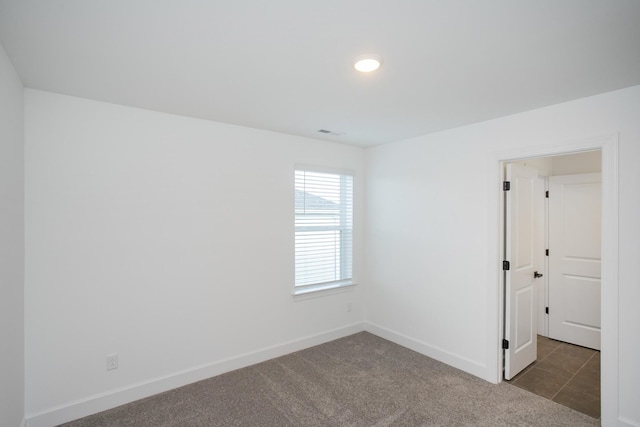 carpeted spare room featuring visible vents, baseboards, and recessed lighting