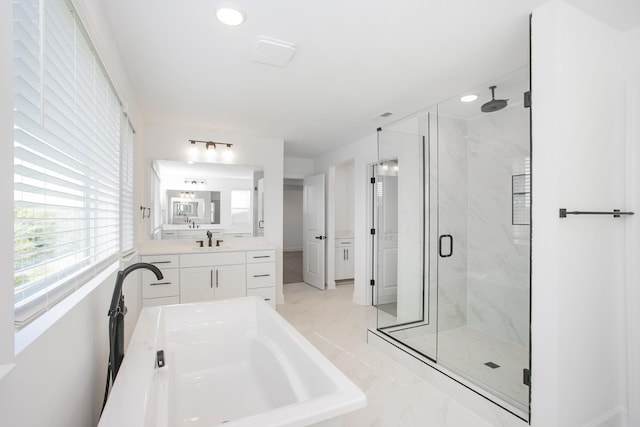 bathroom with recessed lighting, marble finish floor, a washtub, vanity, and a marble finish shower