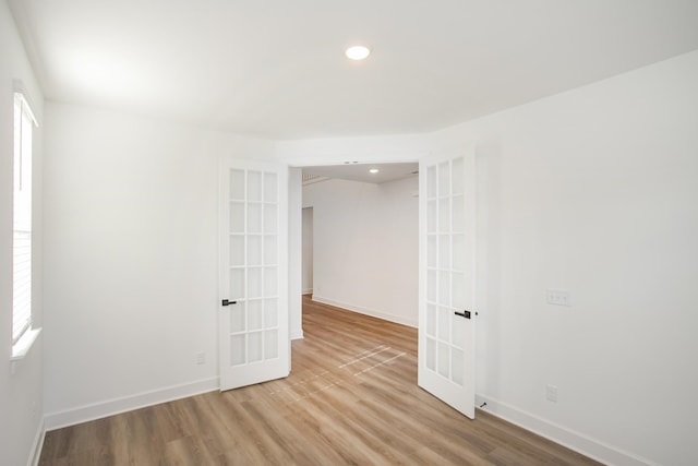 empty room with wood finished floors, french doors, baseboards, and recessed lighting