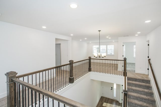 stairs with carpet flooring, a chandelier, baseboards, and recessed lighting