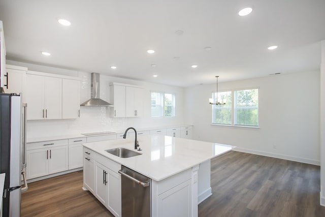 kitchen with a wealth of natural light, wall chimney exhaust hood, stainless steel appliances, and a sink