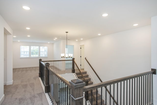 hallway with light carpet, an upstairs landing, a chandelier, and recessed lighting