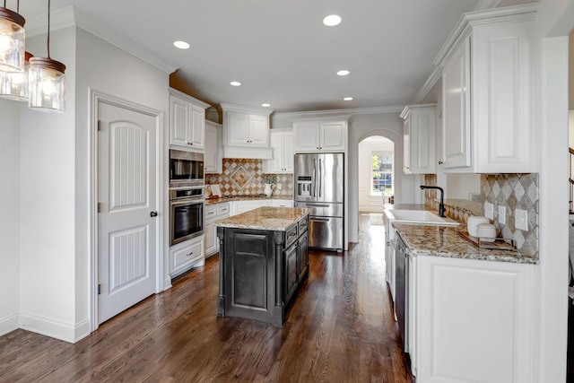 2078 Autumn Ridge Way, Spring Hill, TN 37174 - kitchen featuring appliances with stainless steel finishes, arched walkways, white cabinets, dark wood-type flooring, and crown molding