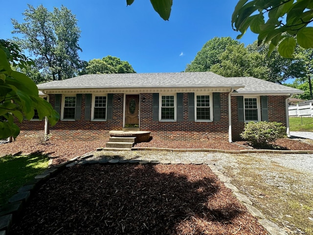 single story home featuring brick siding and a shingled roof