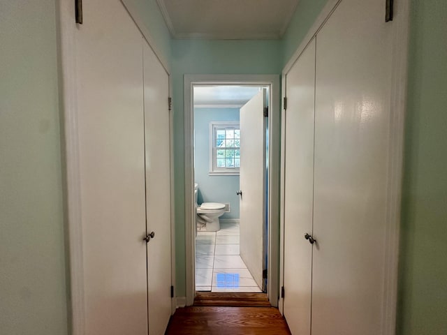 hall featuring wood finished floors and ornamental molding