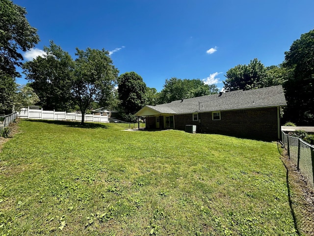 view of yard featuring a fenced backyard and central AC