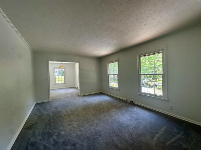 unfurnished room with a wealth of natural light, visible vents, and baseboards