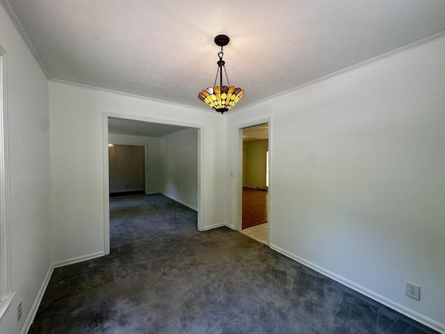 unfurnished dining area featuring baseboards, ornamental molding, and dark colored carpet