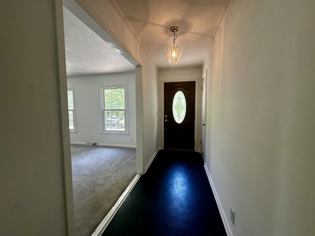 entryway with baseboards and dark carpet