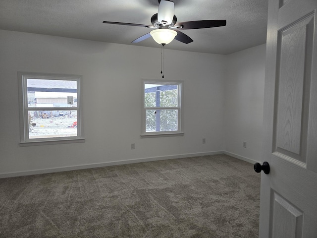 unfurnished room featuring carpet, a textured ceiling, baseboards, and a ceiling fan