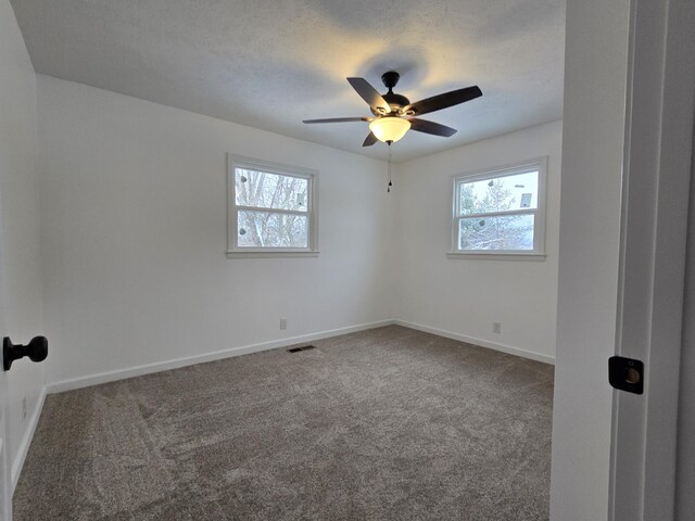 empty room with visible vents, baseboards, ceiling fan, and carpet floors