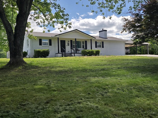 ranch-style home with metal roof, a carport, a chimney, and a front yard