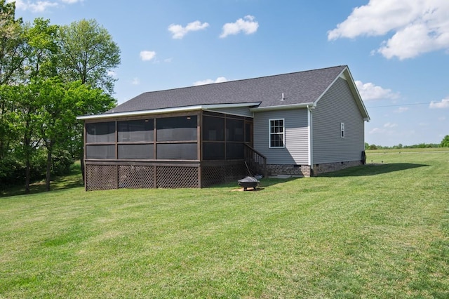 back of property with a lawn, roof with shingles, a sunroom, and crawl space