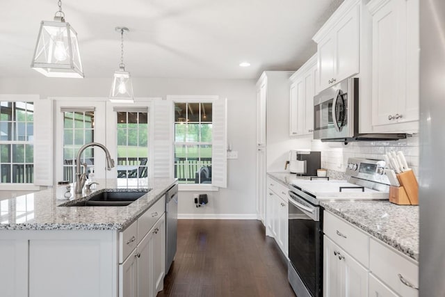 kitchen with a sink, stainless steel appliances, white cabinetry, dark wood-style flooring, and baseboards