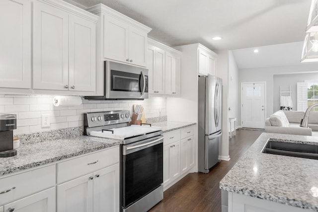 kitchen with a sink, dark wood-style flooring, white cabinetry, and appliances with stainless steel finishes