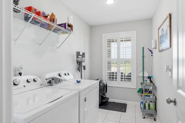 laundry area featuring washing machine and clothes dryer, laundry area, baseboards, and light tile patterned floors