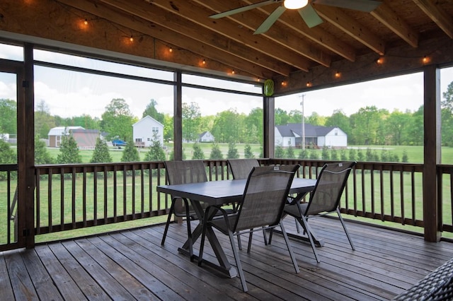 deck featuring outdoor dining space, a lawn, and ceiling fan