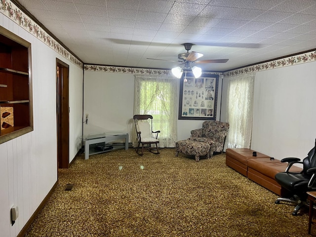 sitting room with carpet, baseboards, and a ceiling fan