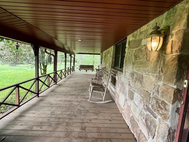 deck with covered porch and a yard