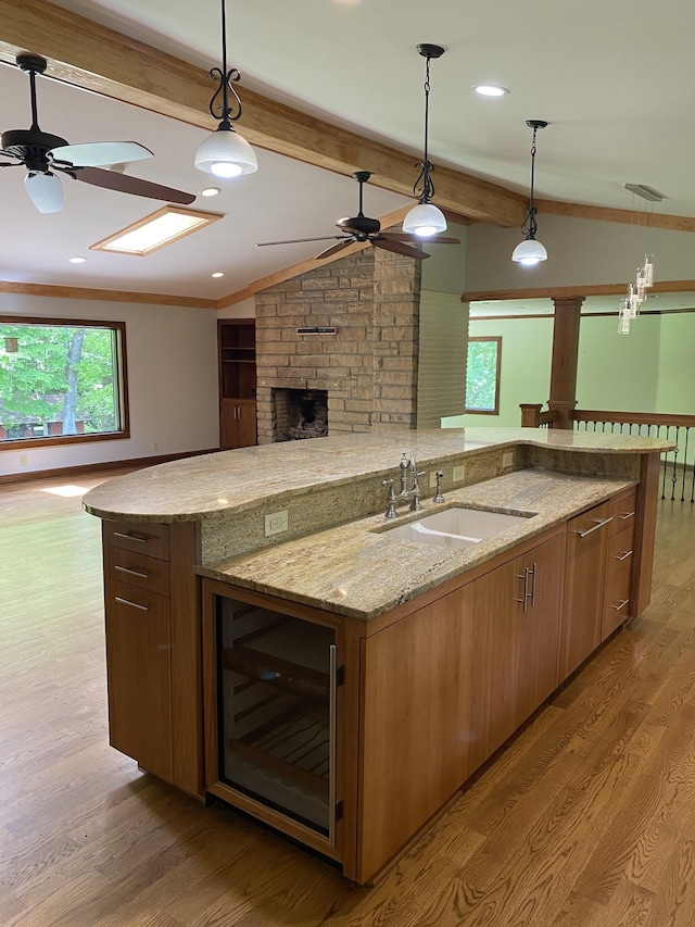 kitchen featuring a sink, a large island, wine cooler, ceiling fan, and open floor plan