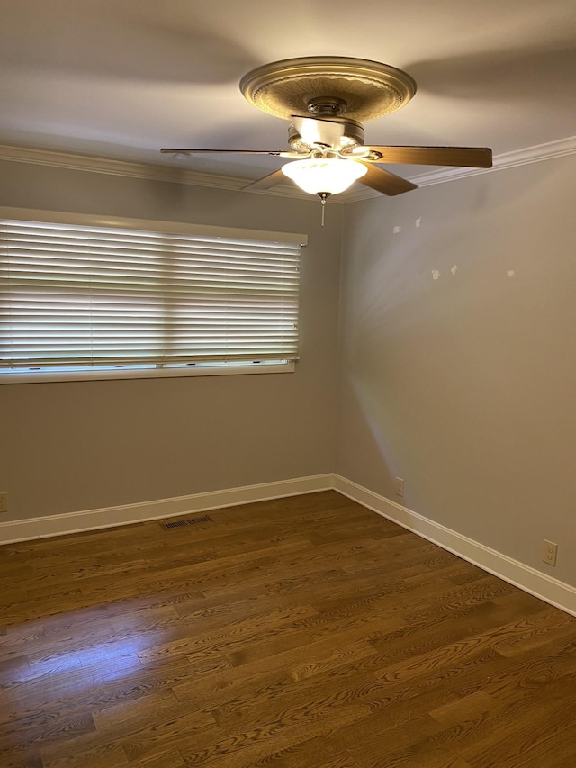unfurnished room with crown molding, ceiling fan, dark wood-style floors, and baseboards
