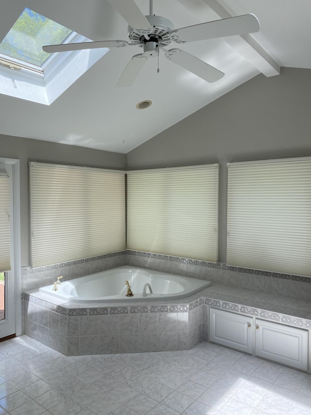 bathroom featuring marble finish floor, lofted ceiling with skylight, a healthy amount of sunlight, and a bath
