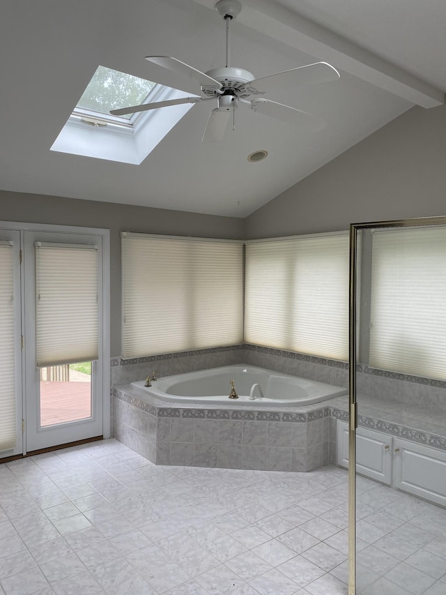 bathroom with vaulted ceiling, a skylight, a bath, tile patterned floors, and a ceiling fan