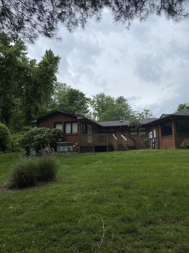 view of green lawn with a deck