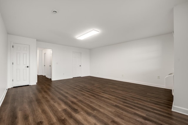 unfurnished room featuring dark wood-style flooring and baseboards